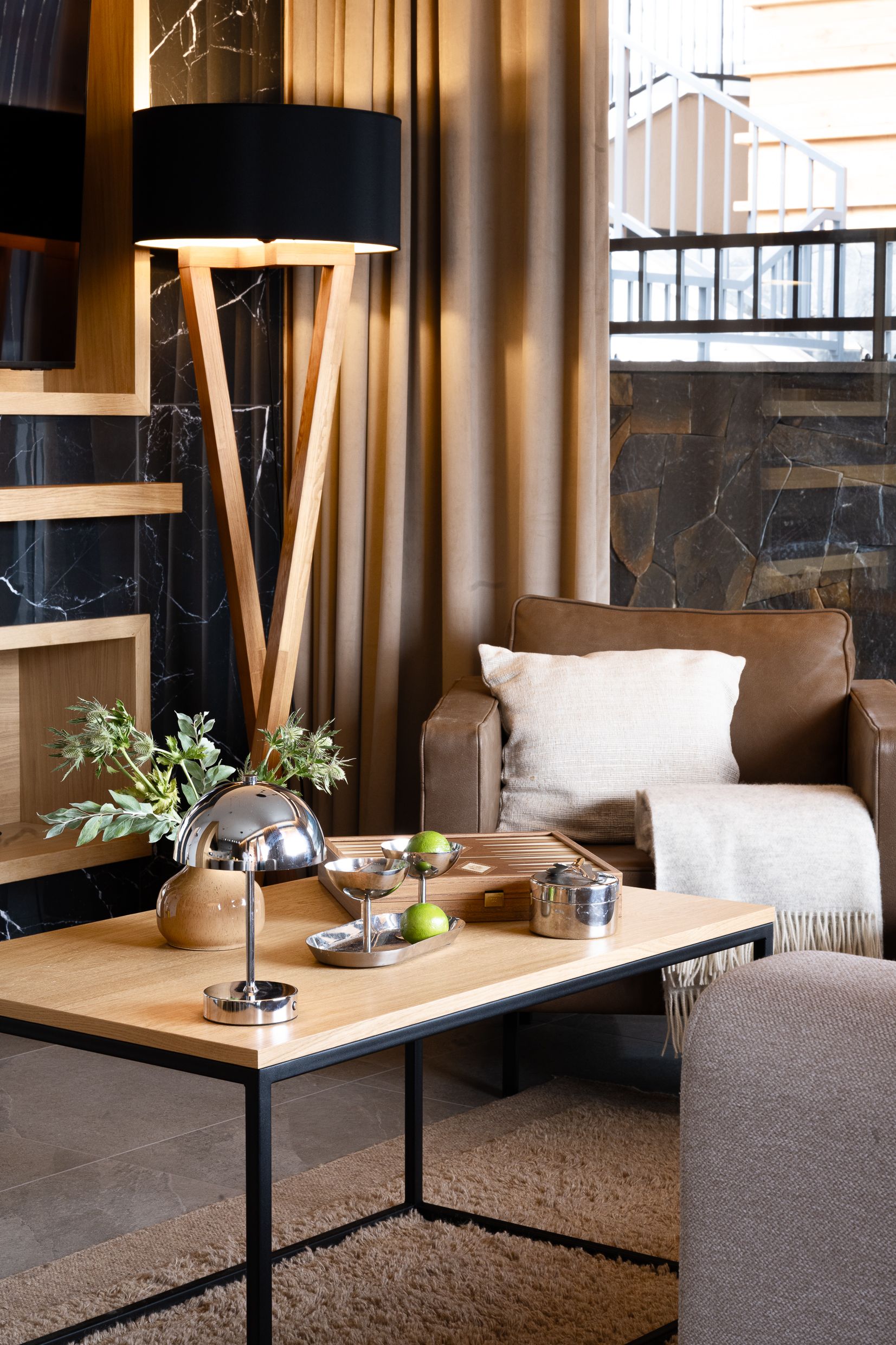 Stylowy salon z drewnianym stolikiem, srebrnymi ozdobami i roślinami