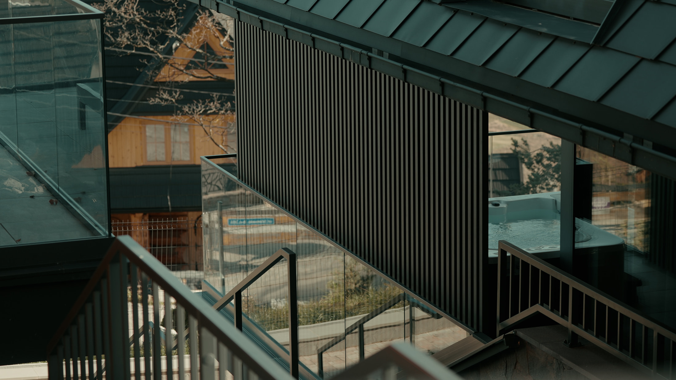 Czarna pionowa lamela w nowoczesnym wnętrzu z szklanymi balustradami